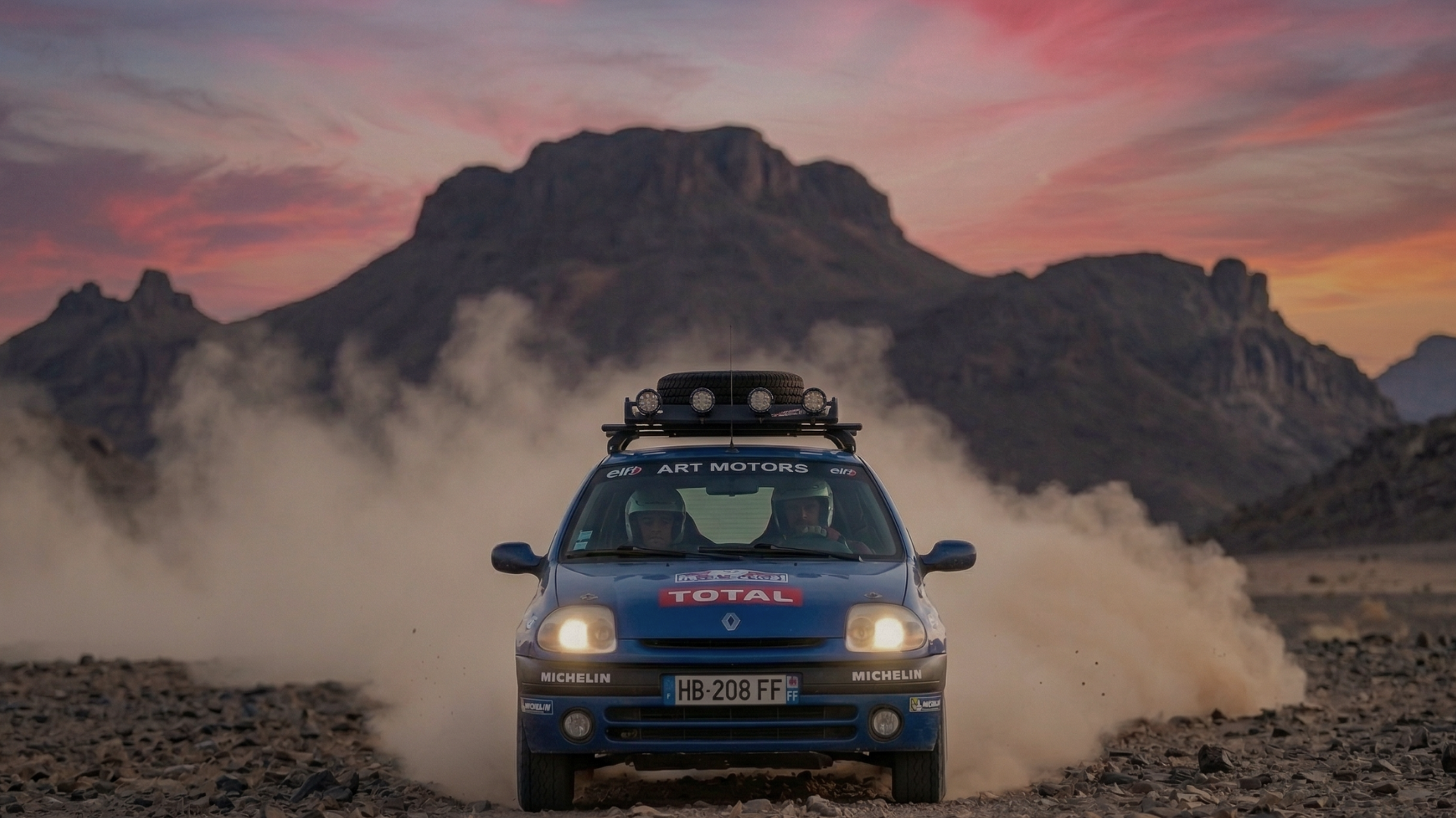 Clio bleue arrivant en face dans la poussière